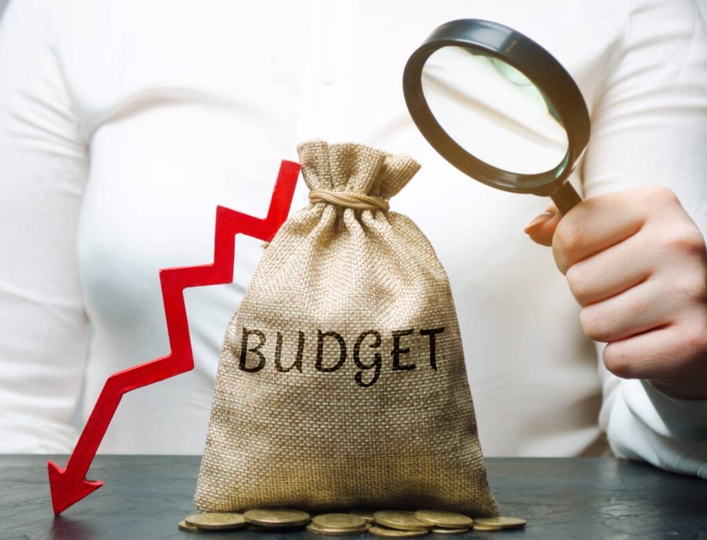 Sac de budget en baisse analysé à la loupe – symbole du manque de financement en communication dans les OBNL