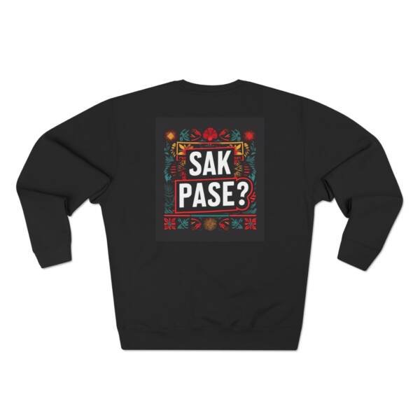 Sweatshirt noir avec l’inscription “SAK PASE?” en blanc et rouge, entourée de motifs haïtiens traditionnels. Design inspiré de la culture créole et de l’article de blog sur la salutation haïtienne de Anprent Berwin.
