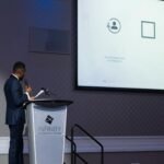 Berwin Sydney au lutrin de l Infinity Convention Centre, micro a la main